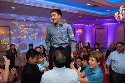Boy smiling during hora at Bat Mitzvah in Torrance