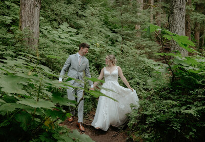 A couple holding hands and walking on a trail near Virgin Creek Falls. 