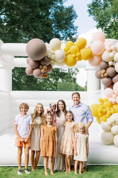Family smiling in front of a bouncy castle