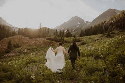 Couple walks through wildflowers in Colorado