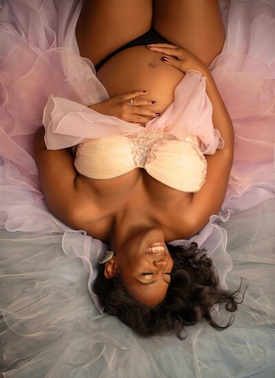 Los Angeles Luxury Maternity Photographer - Mom laying down on tulle happy and excited