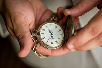 Close up of hands holding a pocket watch