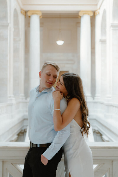 elegant photo of couple hugging from behind while staring in each other's eyes