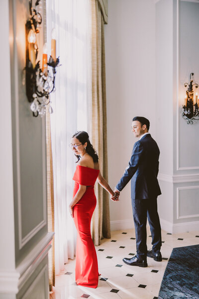 Indian and chinese bride and groom at their fusion wedding in front of a big window at the hilton pearl river