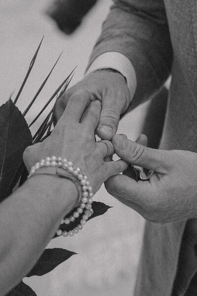 Detail van de handen van een bruidspaar terwijl de ringen omgaan