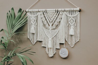 white macrame is hanging on a beige wall