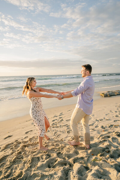 man and woman holding hands on the beach