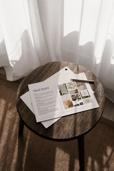 Flat lay of brand strategy documents and creative direction guide on a wooden table, part of the Moonstone Brand Star Chart process.