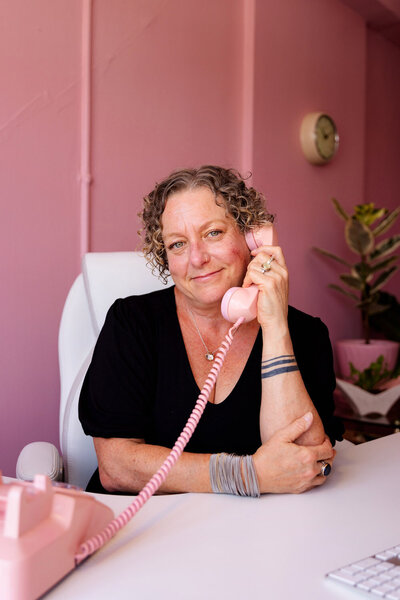 Oregon business lawyer Cassie Peters sits at her desk and hold a phone to her ear. 