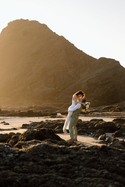 Bride holding up a bouquet of flowers during a beach elopement in Michigan.