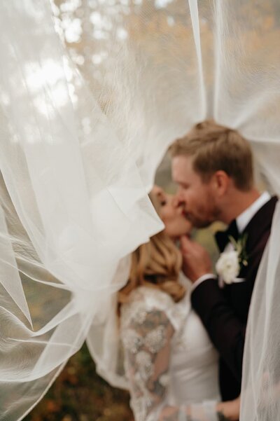 bride and groom embrace under veil