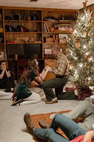 boyfriend proposing to girlfriend during christmas party with friends shocked