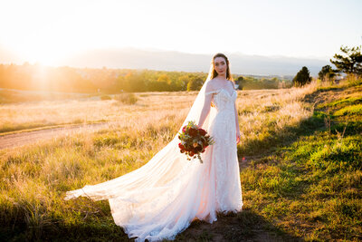 A bride stands on the couch in her white robe and dances in celebration.