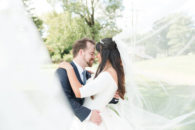 couple embracing under their wedding veil