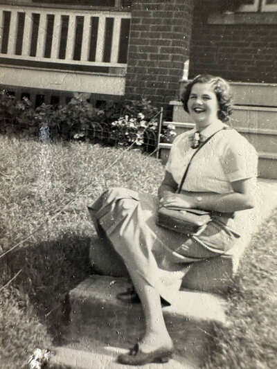 black and white photo of Sybil Hicks sitting outside on a walkway