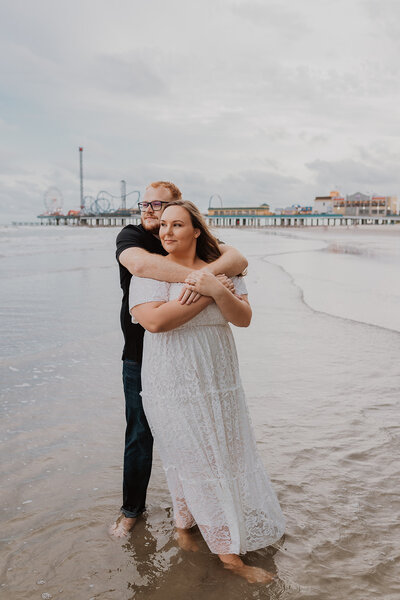 A couple dance at Galveston Island Beach during an engagement photo session