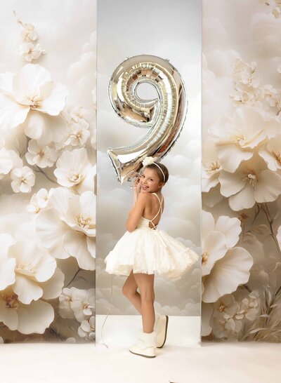 Toddler girl sitting on stool with balloon filled #2 marquee. Set up was created by Jenni Nikki Photography at her Woodstock Photo Studio near Atlanta GA.