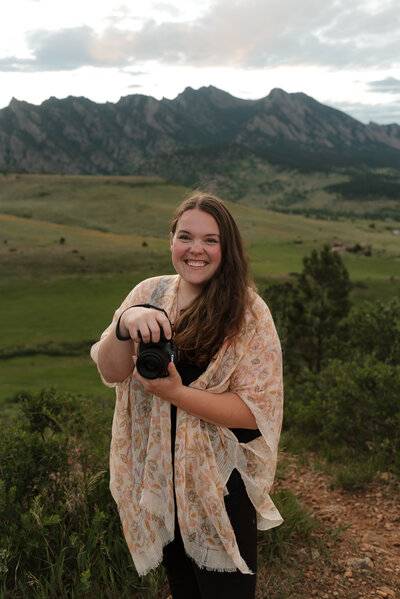 Photo of Alexis Adkins Photography holding camera in hand and smiling in Boulder Colorado