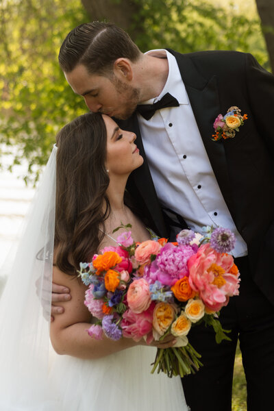 bride and groom at their private residence wedding ceremony in janesville wisconsin, bride holding bouquet of bright and colorful spring flowers