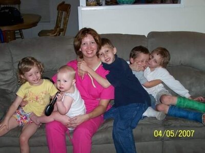 Crystal McClurg sitting on the couch with her five children when they were little