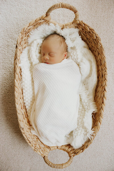 newborn swaddled in basket