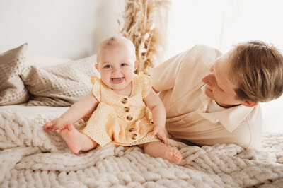 During a Milestone session a momma snuggles and giggles with her little one at the studio of Nikii Pix Photography, Bismarck, ND