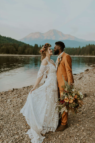 bride & groom kissing by the lake