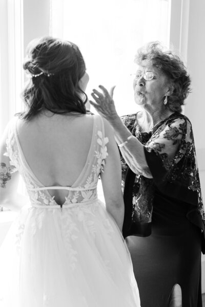 a grandmother helps her granddaughter into her wedding dress at her northstar house wedding