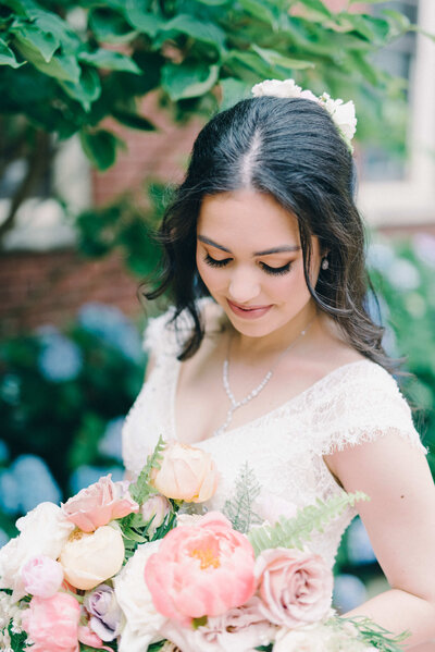 A bride looking down at her bouquet outside at St Paul's Cathedral Birmingham