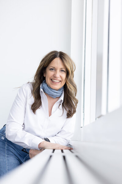 wedding photographer smiling while touching her hair and holding a camera