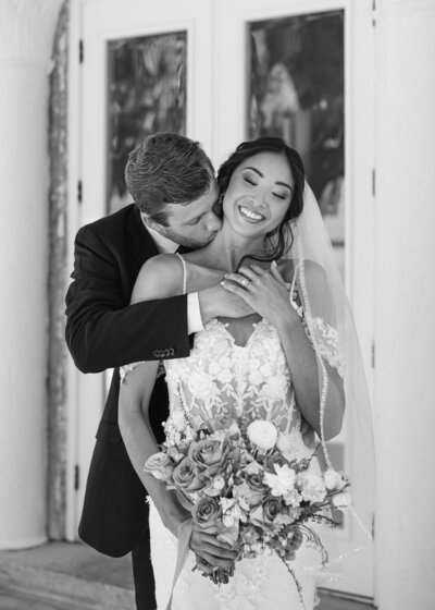 Groom kissing brides neck Bella Cosa Wedding Venue -Lake Whales-Florida