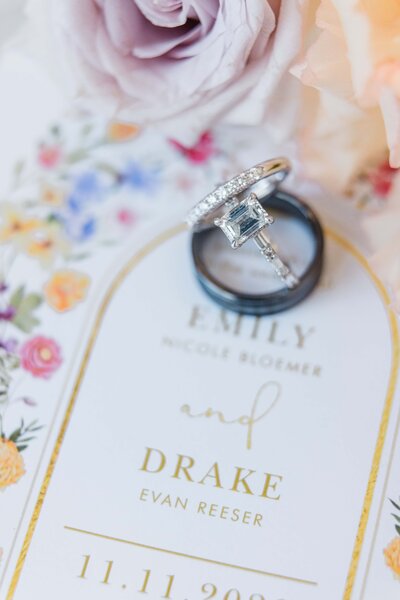 Close-up of an engagement ring on a floral wedding invitation, designed by a prominent Illinois wedding planner, with names Nicole Bloeme and Drake Evan Reeser, dated 11.11.2026