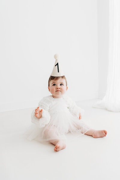 Baby girl with a birthday hat on