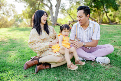 family laughs in grass