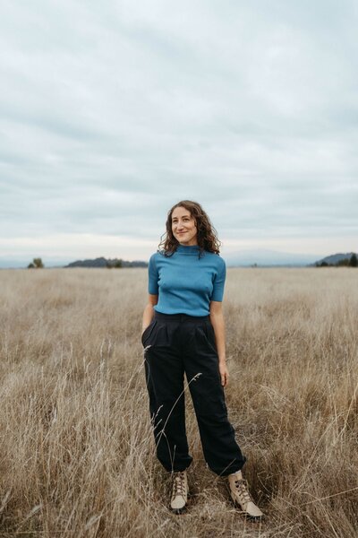 A person smiling as they lean down and pet a dog 