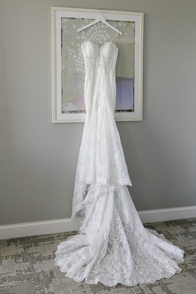 wedding dress hanging on a picture frame in hotel room
