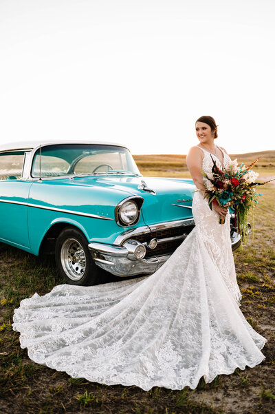 Bride in front of old car