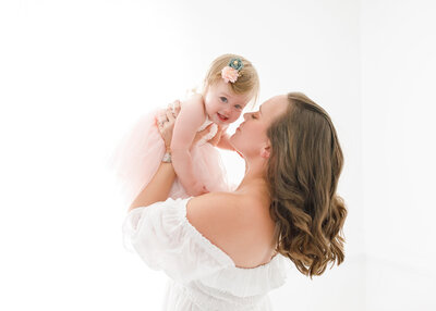 mom holding her smiling baby in the air