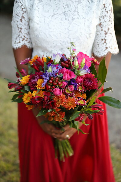 Woman standing and holding a bouquet of beautiful multi-colored flowers