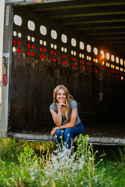 senior girl in a western styled horse trailer