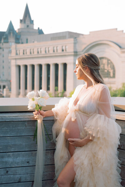 Expecting mother in Ottawa Holding belly and holding flowers