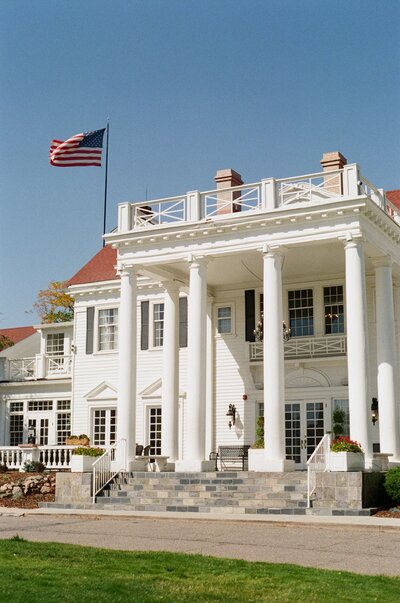Exterior of the front of The Manor House in Littleton, a historic Colorado wedding venue with classic white-column architecture.