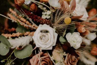 woman holding locket on wedding bouquet