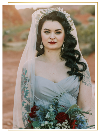 Image of bride holding bridal bouquet wearing wedding dress with vintage style hair and makeup