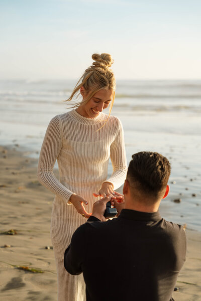 a woman being proposed to on a beach 