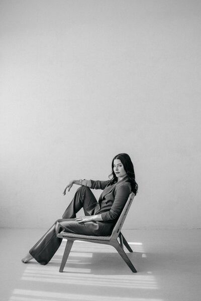 Frau lacht, während sie im Atelier steht und in die Kamera schaut.