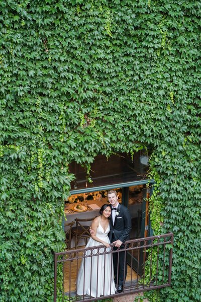 Bride and groom standing on a balcony at the Ivy Room for their wedding photos in Chicago
