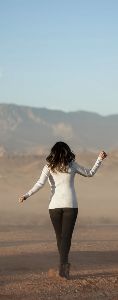 woman skipping away from camera in nature