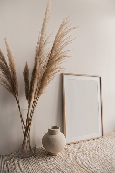 Neutral coloured picture frame and vase with plants for the background of a website design services section