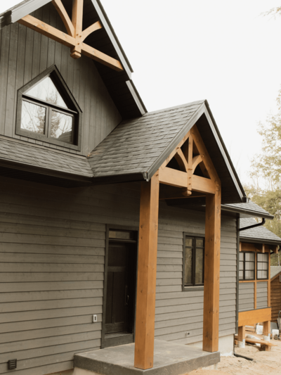 Timber frame house construction near Haliburton lakes, blending luxury home design with rugged Canadian wilderness.